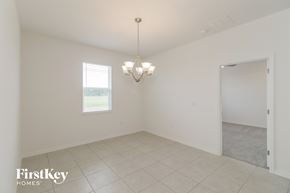 Bartow house for rent - A large empty room with a chandelier and a window.