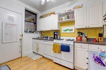 Chicago apartment for rent - A kitchen with white cabinets and a white stove top oven.