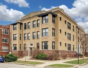Chicago apartment for rent - A large brick building with a blue car parked in front.