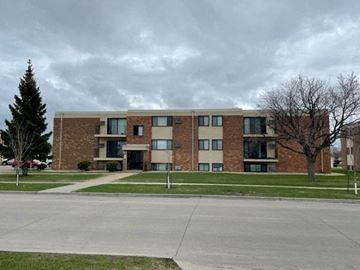 West Fargo apartment for rent - a large brick apartment building on a cloudy day