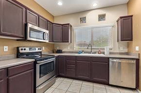 Oro Valley house for rent - a kitchen with brown cabinets and stainless steel appliances