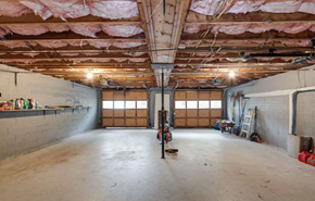 Greenville house for rent - A spacious garage with a concrete floor and walls, and a ceiling covered with insulation.