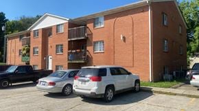 Batavia apartment for rent - A red brick building with a white garage door and a black truck parked in front.