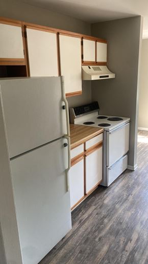 Batavia apartment for rent - A white refrigerator with wooden handles and a white stove with a hood above it.
