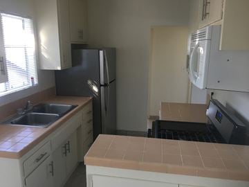 Santa Barbara apartment for rent - A kitchen with a black refrigerator and white cabinets.
