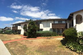 Goleta apartment for rent - A white building with a red walkway in front.