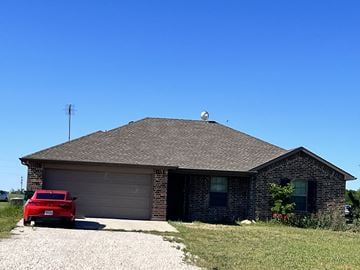 Ponder house for rent - A red car is parked in front of a house.