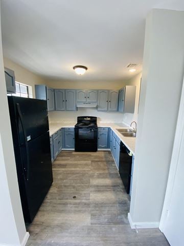 Lafayette apartment for rent - an empty kitchen with black appliances and blue cabinets