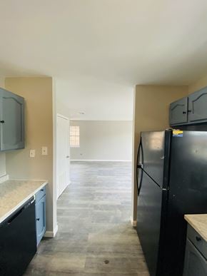 Lafayette apartment for rent - an empty kitchen with black appliances and a hallway to the living room