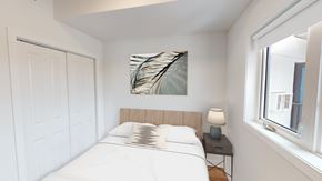 Winnipeg apartment for rent - A bedroom with a white bed and a painting on the wall.