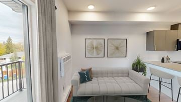 Winnipeg apartment for rent - A living room with a white couch and a small kitchen area.