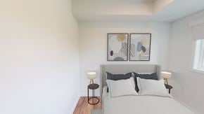 Winnipeg apartment for rent - A bedroom with a bed, two lamps, and two framed pictures on the wall.
