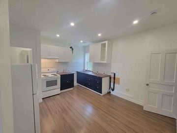 Westville apartment for rent - A kitchen with a white fridge, black dishwasher and wooden floors.