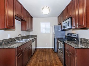 Palm Springs apartment for rent - a kitchen with wooden cabinets and stainless steel appliances