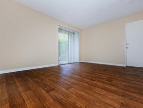 Palm Springs apartment for rent - an empty living room with wood floors and a sliding glass door
