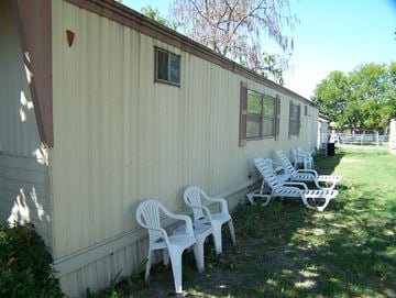 Princeton apartment for rent - A row of white plastic chairs are lined up on a lawn in front of a tan building.