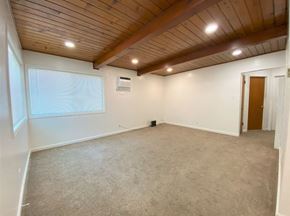 Merced house for rent - A room with a wooden ceiling and carpeted floor.