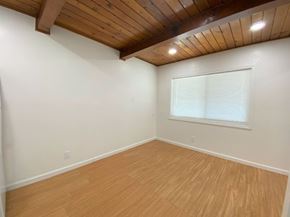 Merced house for rent - A room with wooden flooring and a window with blinds.