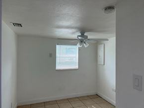 Fort Myers apartment for rent - A room with a ceiling fan and a window with blinds.
