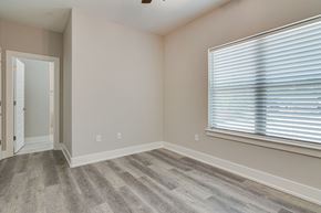 Krum apartment for rent - an empty bedroom with a large window and wood flooring