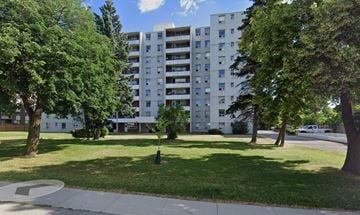 Stoney Creek apartment for rent - A large white apartment building with a green lawn in front.