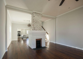 Greenville house for rent - A large, empty room with a fireplace and wooden floors.