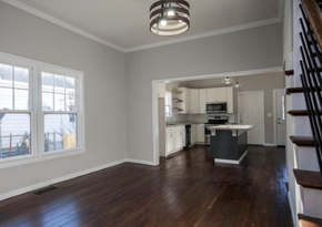 Greenville house for rent - A spacious kitchen and living room with hardwood floors and white walls.