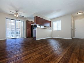 Indio apartment for rent - an empty living room with a kitchen and a ceiling fan