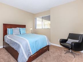Palm Springs apartment for rent - a bedroom with a bed and a chair and a window