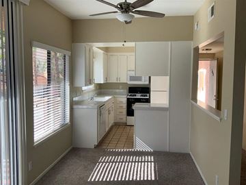 Palm Springs apartment for rent - a white kitchen with a ceiling fan and a window