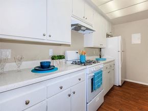 Palm Springs apartment for rent - a kitchen with white cabinets and a stove and a refrigerator