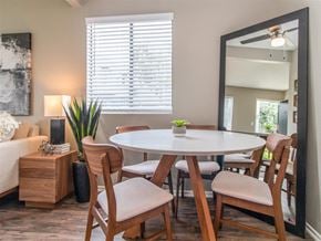Hemet apartment for rent - a dining room with a table and chairs and a mirror