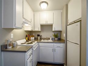 Hemet apartment for rent - a kitchen with white cabinets and a white refrigerator