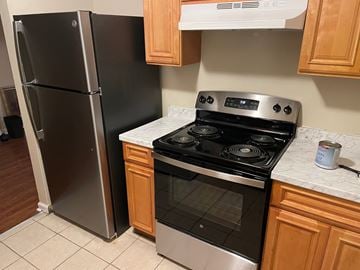 Memphis apartment for rent - A black refrigerator stands next to a stove in a kitchen.