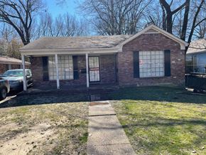 Memphis apartment for rent - A small brick house with a porch and a car parked in front.