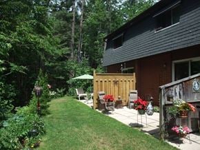 Gravenhurst apartment for rent - A backyard with a wooden fence and a green umbrella.