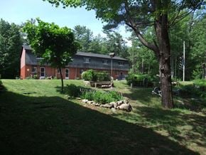 Gravenhurst apartment for rent - A red house with a green lawn in front of it.