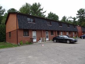 Gravenhurst apartment for rent - A black car is parked in front of a brick building.