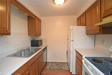 Dayton house for rent - A kitchen with wooden cabinets and a white fridge.