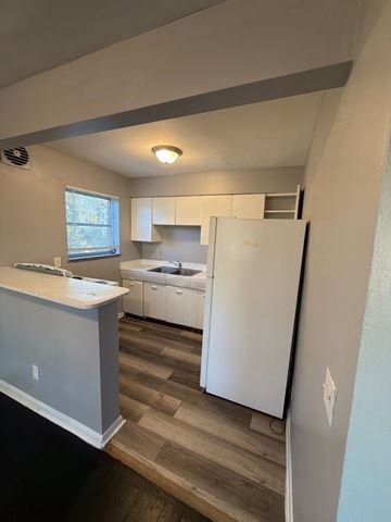 Cincinnati apartment for rent - A kitchen with a white fridge and a window.