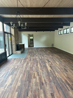 Fairfield house for rent - an empty living room with wood floors and a fireplace