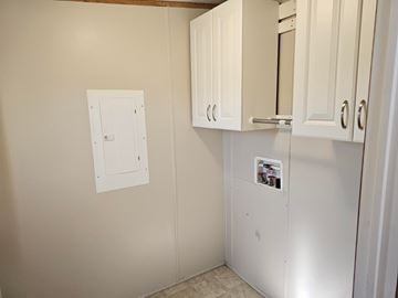 Shawnee house for rent - A white kitchen cabinet with a fridge and a white switchboard on the wall.