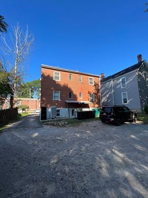 Cincinnati apartment for rent - A black car is parked in front of a brick building.