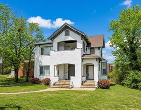 Cincinnati apartment for rent - A white two-story house with a front porch and a green door.