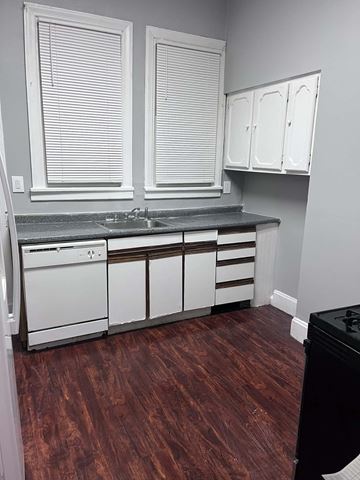 Cincinnati apartment for rent - A kitchen with white cabinets and a black dishwasher.