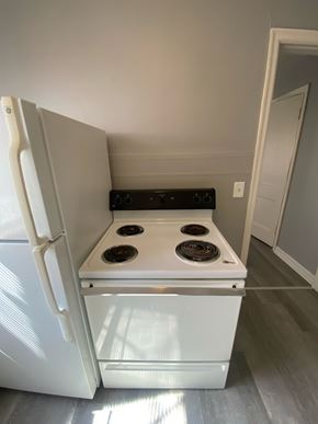 Cincinnati apartment for rent - A white fridge with the door open and a stove below it.