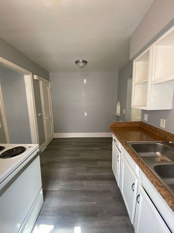 Cincinnati apartment for rent - A kitchen with a stove top oven and a sink.
