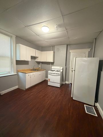 Cincinnati apartment for rent - A kitchen with white appliances and wooden floors.