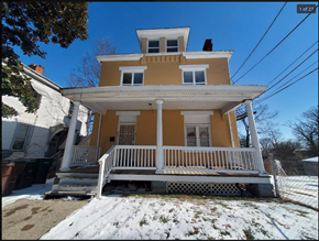 Cincinnati apartment for rent - A yellow house with a white porch and a brown roof.
