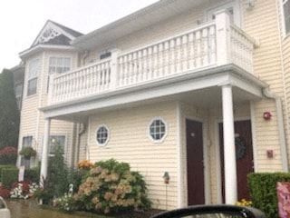 West Babylon apartment for rent - a yellow house with a white balcony on top of it